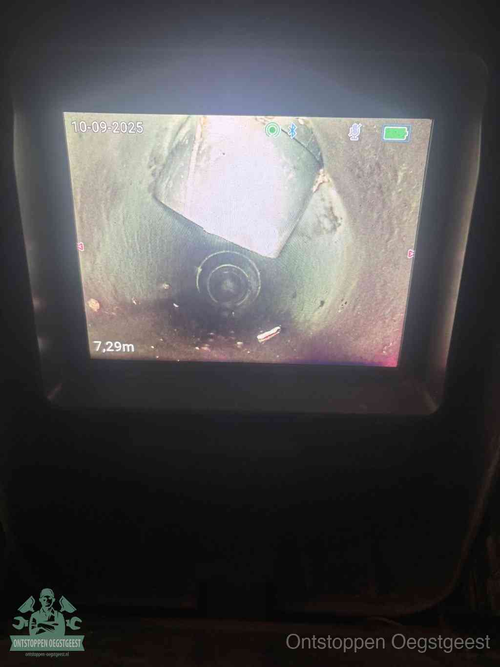 Het scherm van een rioolinspectiecamera toont de binnenkant van de leiding, eerst vaststellen waar de verstopping zit in Oegstgeest